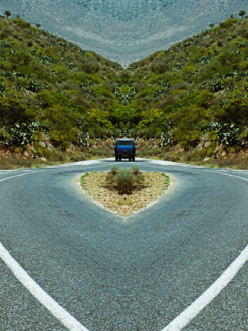 Okładka płyty In Reverse zespołu Lola Lynch, przedstawiająca szosę w górach, zdjęcie powstało poprzez lustrzane odbicie jednej połowy obrazu co daje efekt nienaturalnej symetrii